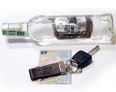 Na zdjeciu widoczna butelka po wódce obok kluczyki i dowód rejestracyjne pojazdu. 