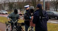 Policjanci podczas działań &quot;NURD&quot; rozmawiają z rowerzystami i przekazują im opaski odblaskowe.