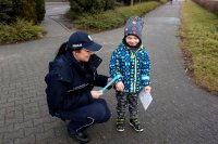 Policjantka zakłada chłopczykowi odblask na rączkę.