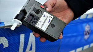 Na zdjęciu policjant trzymający w ręku urządzenie do badania stanu trzeźwości o nazwie Alco Sensor