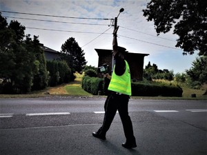 Na zdjęciu policjant ruchu drogowego trzymający tarczę do zatrzymywania pojazdów.