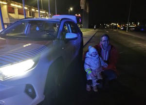 Na zdjęciu mężczyzna z dzieckiem przy samochodzie z napisem Radio Express.
