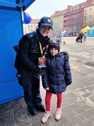 Na zdjęciu policjantka oraz dziecko podczas tyskiego 32. Finału Wielkiej Orkiestry Świątecznej Pomocy.