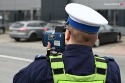 Na zdjęciu umundurowany policjant mierzący prędkość.